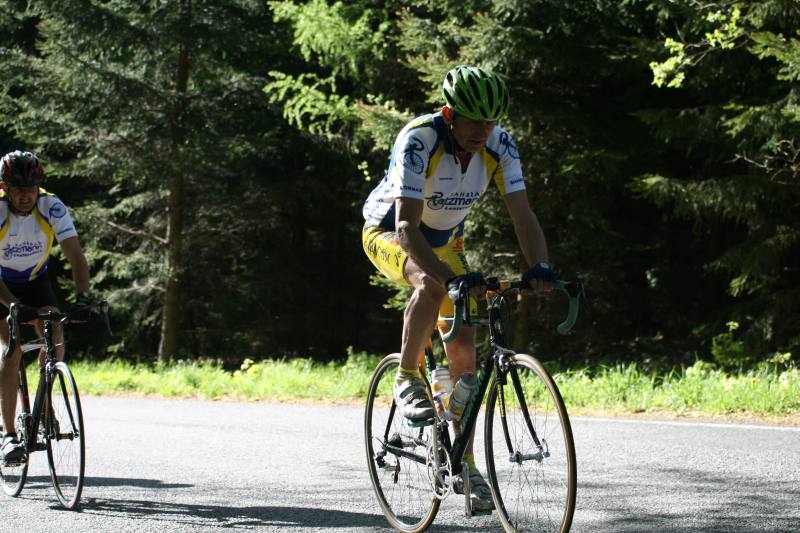 zwei &auml;ltere Herren mit erklimmen mit Rennr&auml;dern eine Steigung auf einer Asphaltstra&szlig;e