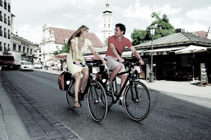 Ein Paar f&auml;hrt mit ihren Trekkingr&auml;dern nebeneinander her und schaut sich dabei liebevoll in die Augen.